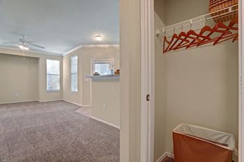 an empty living room with a closet and a laundry room